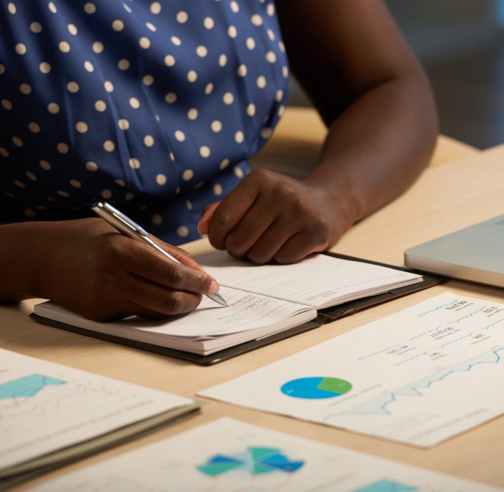 Cropped image of business lady taking notes in her planner